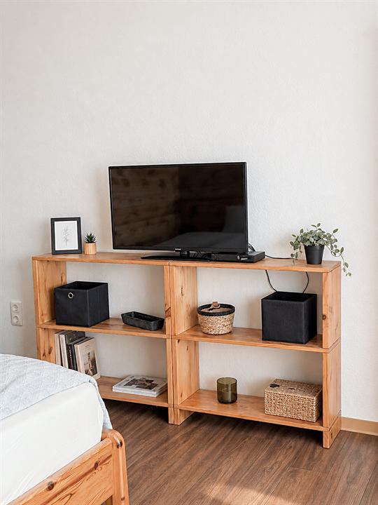Regal mit Fernseher neben dem Bett