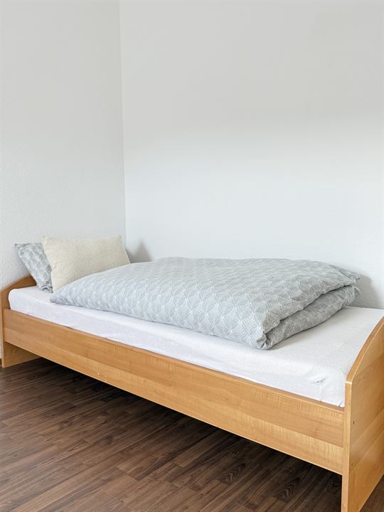 Einzelbett mit Holzrahmen