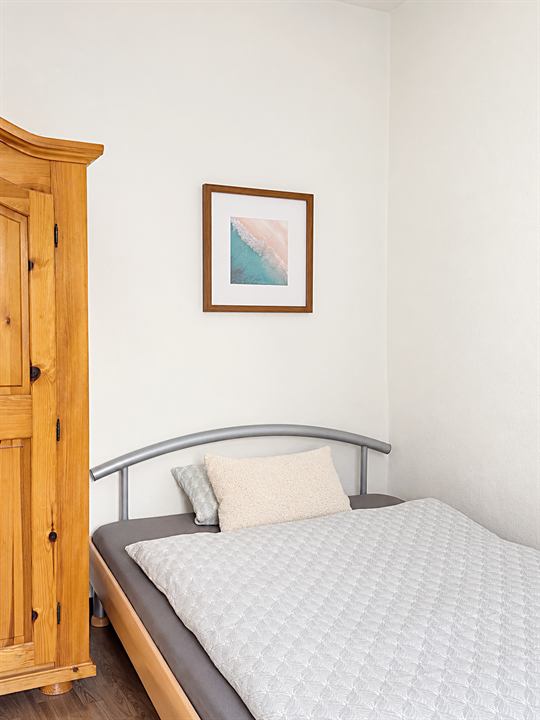 Schlafzimmer mit Holzschrank und Bett